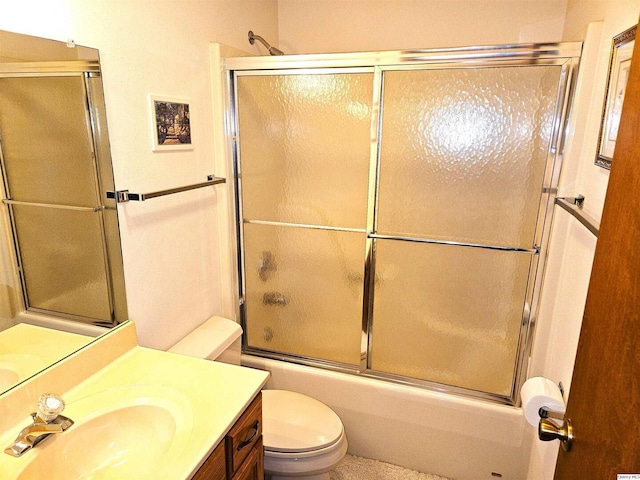 full bathroom featuring vanity, combined bath / shower with glass door, and toilet