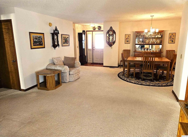 carpeted living room featuring an inviting chandelier and a textured ceiling