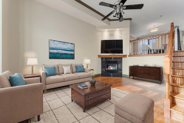 living room featuring ornamental molding, ceiling fan, a high end fireplace, and light hardwood / wood-style flooring