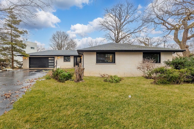 single story home with a garage and a front lawn