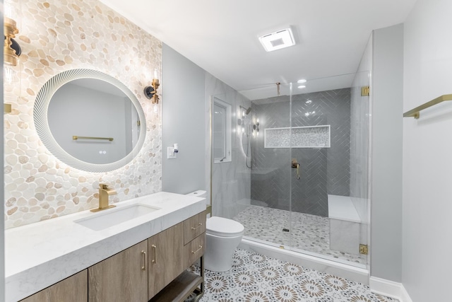 bathroom featuring vanity, tiled shower, and toilet