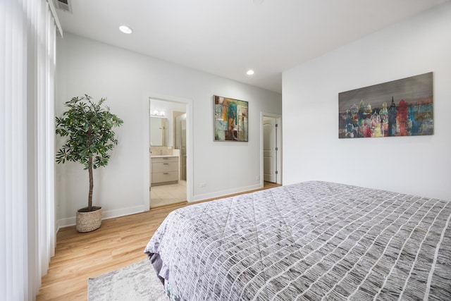 bedroom featuring ensuite bathroom and wood-type flooring