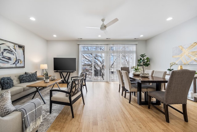 dining space with ceiling fan and light hardwood / wood-style flooring