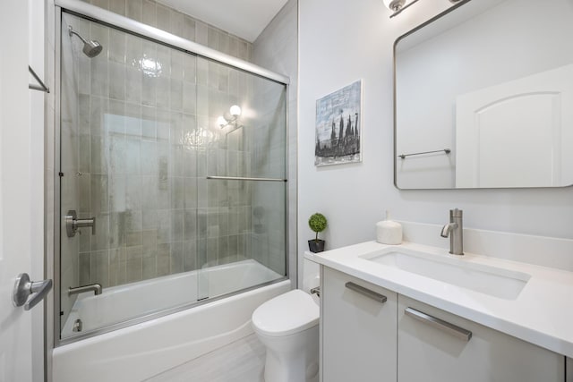 full bathroom with vanity, shower / bath combination with glass door, and toilet