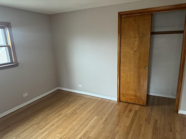 unfurnished bedroom featuring light hardwood / wood-style flooring and a closet