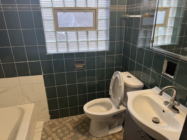 bathroom featuring tile walls, tile patterned flooring, vanity, a bath, and toilet