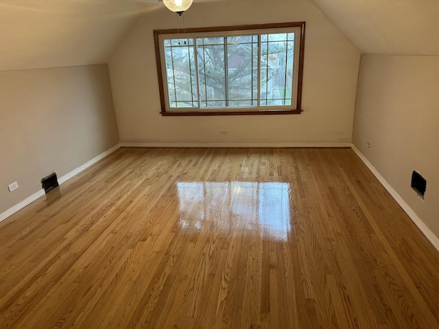 bonus room featuring vaulted ceiling and light wood-type flooring