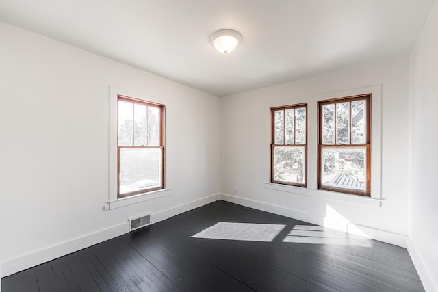 unfurnished room with plenty of natural light and dark hardwood / wood-style floors