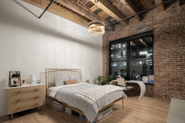 bedroom featuring brick wall, a chandelier, wooden ceiling, beam ceiling, and light hardwood / wood-style flooring