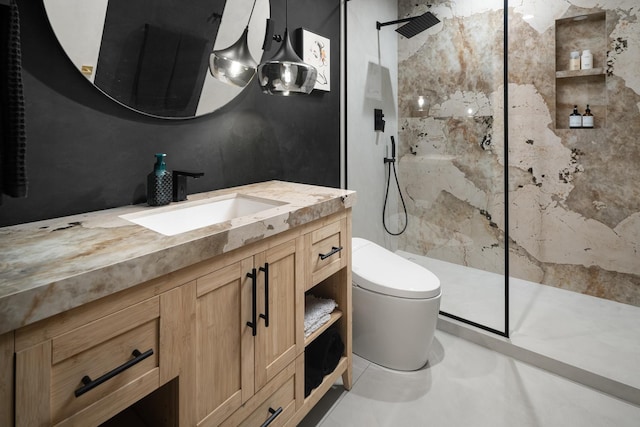 bathroom featuring vanity, tiled shower, and toilet