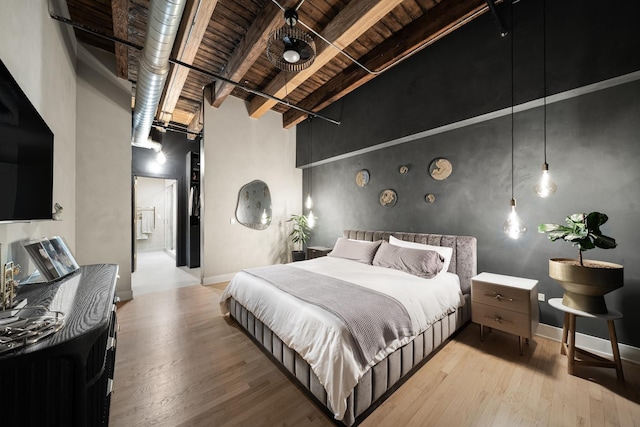 bedroom with beam ceiling, light wood-type flooring, and wooden ceiling