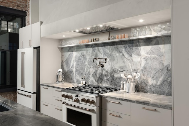 kitchen with premium appliances, backsplash, and white cabinets