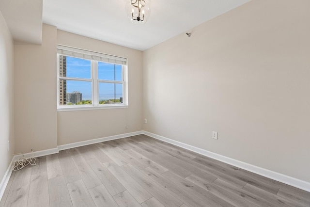 5 E 14th Pl Unit 801, Chicago, IL 60605 - unfurnished room with light wood-type flooring, baseboards, and a chandelier