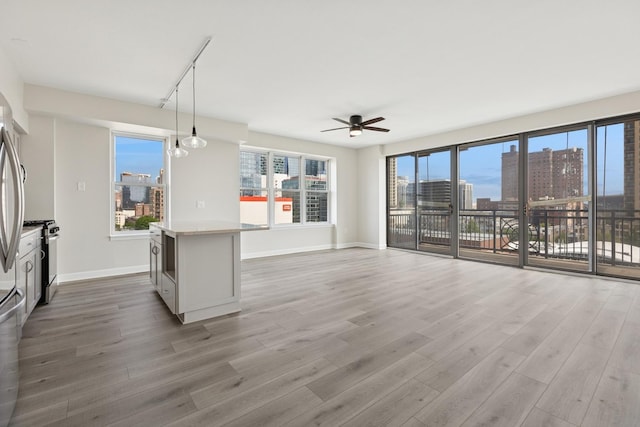 5 E 14th Pl Unit 801, Chicago, IL 60605 - unfurnished living room featuring ceiling fan, a city view, light wood-type flooring, and baseboards