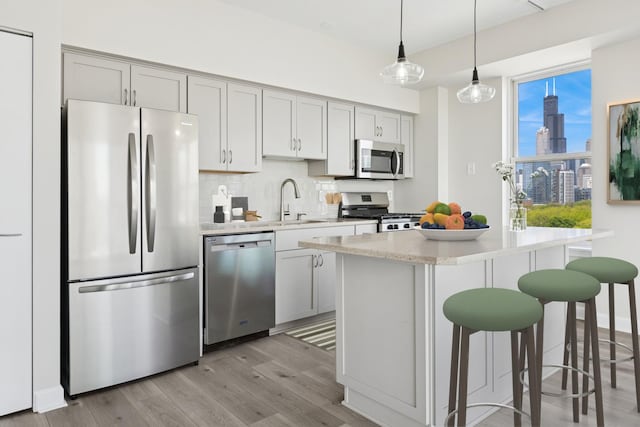 5 E 14th Pl Unit 801, Chicago, IL 60605 - kitchen featuring stainless steel appliances, light wood-type flooring, a breakfast bar area, decorative backsplash, and a sink