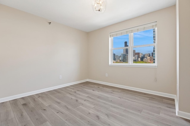 5 E 14th Pl Unit 801, Chicago, IL 60605 - spare room with baseboards, light wood-style flooring, and a skyline view