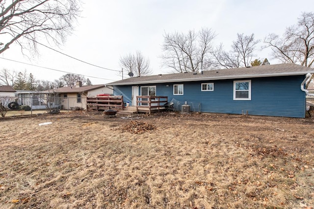 back of house featuring central AC unit, a lawn, and a deck