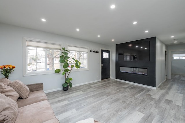 living room featuring a large fireplace and light wood-type flooring