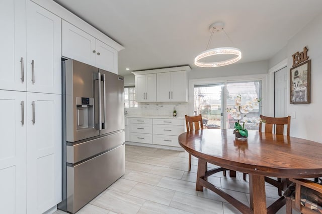 kitchen with white cabinetry, high quality fridge, plenty of natural light, and tasteful backsplash