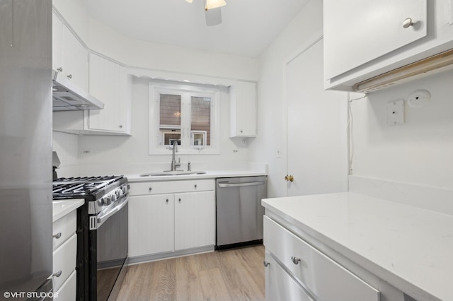 kitchen with white cabinetry, appliances with stainless steel finishes, sink, and light hardwood / wood-style flooring