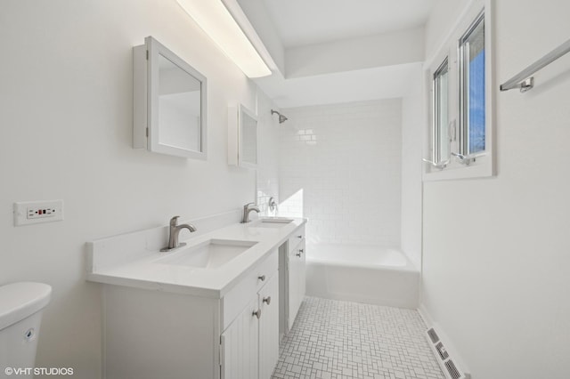 full bathroom with vanity, tiled shower / bath combo, tile patterned floors, and toilet