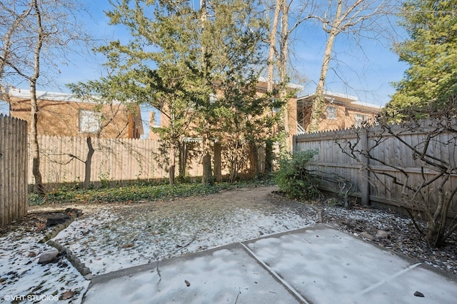 yard covered in snow featuring a patio