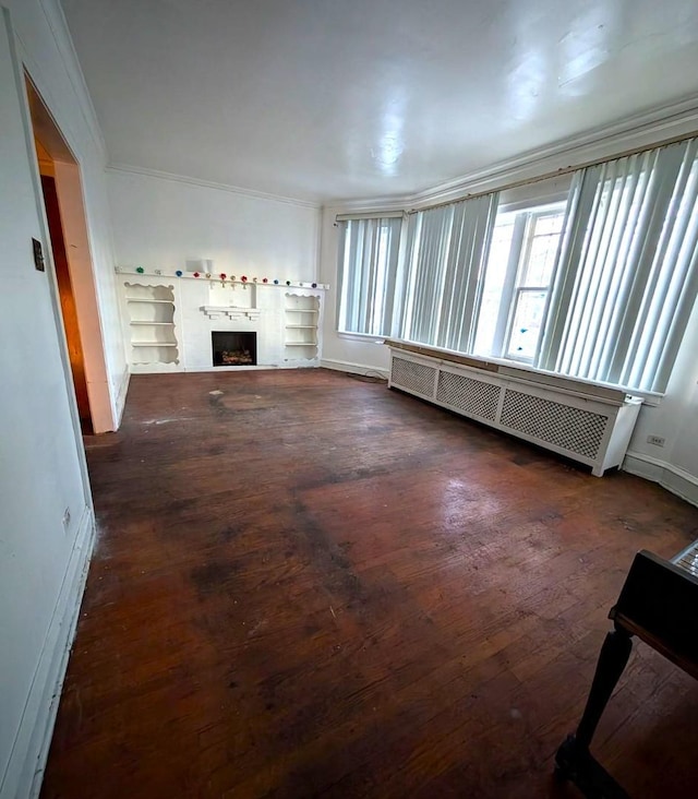 unfurnished living room with crown molding, dark hardwood / wood-style floors, and radiator heating unit