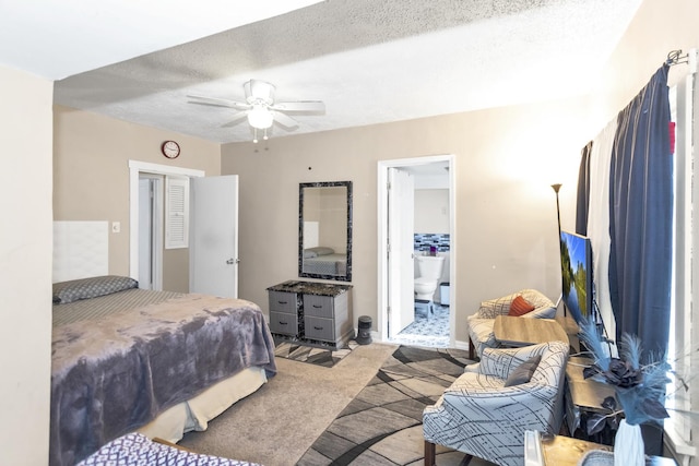 carpeted bedroom featuring ceiling fan, ensuite bathroom, and a textured ceiling