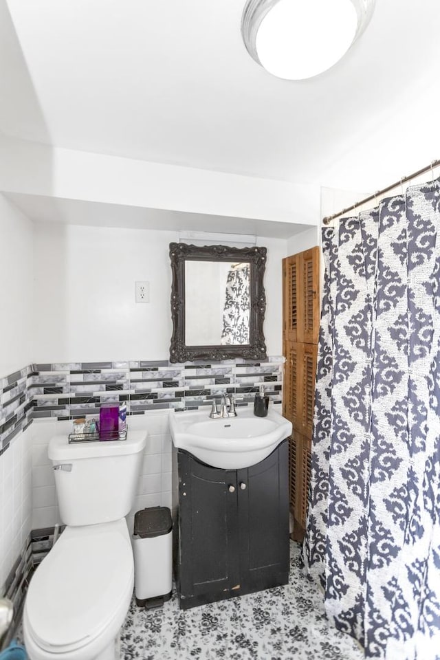 bathroom featuring vanity, toilet, a shower with shower curtain, and tile walls