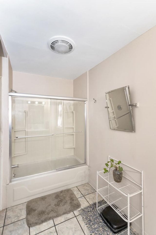 bathroom with tile patterned floors and shower / bath combination with glass door