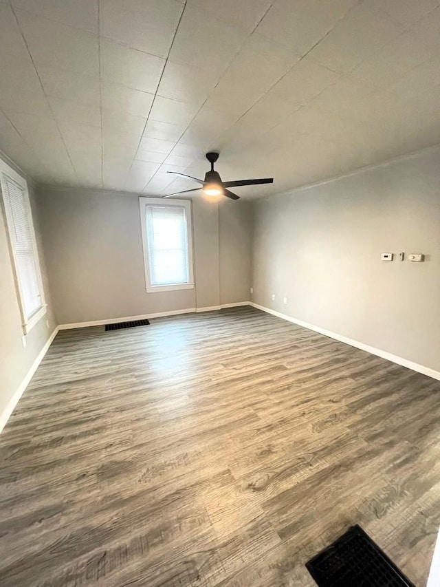 empty room with hardwood / wood-style floors and ceiling fan