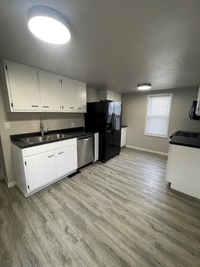 kitchen featuring sink, white cabinets, stainless steel dishwasher, light hardwood / wood-style floors, and black refrigerator with ice dispenser