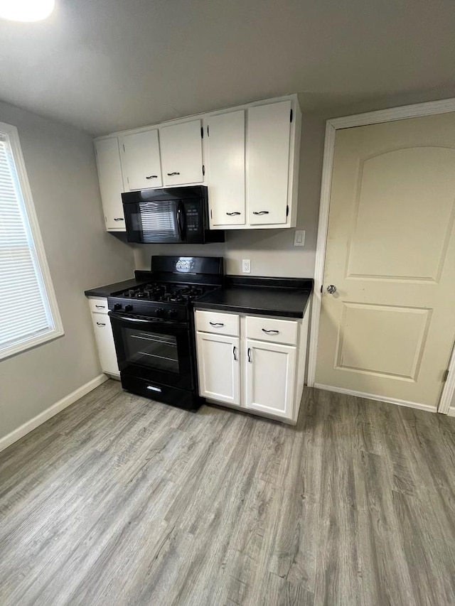 kitchen featuring white cabinetry, plenty of natural light, light hardwood / wood-style floors, and black appliances