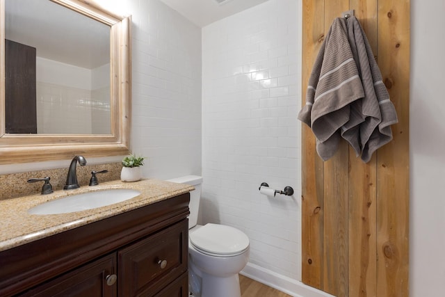 bathroom with vanity, toilet, and hardwood / wood-style floors