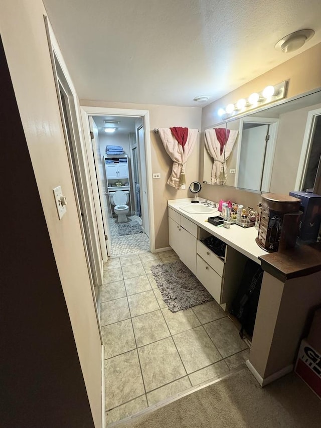 bathroom featuring vanity, toilet, and tile patterned flooring