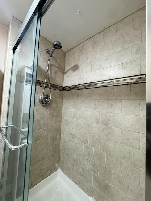 bathroom with a shower with door