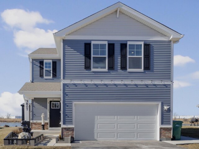 view of property featuring a garage, a front yard, and a porch