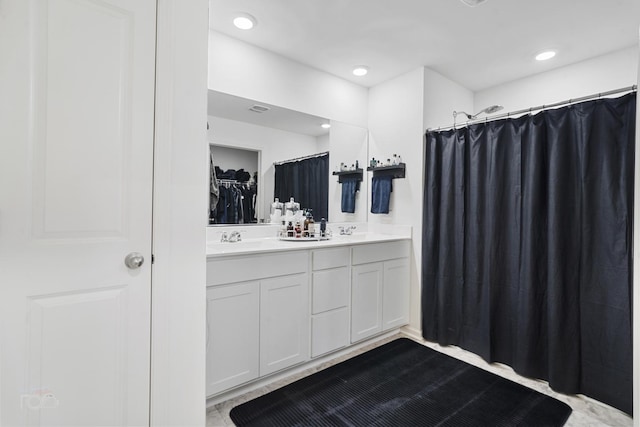 bathroom with recessed lighting, a sink, and double vanity