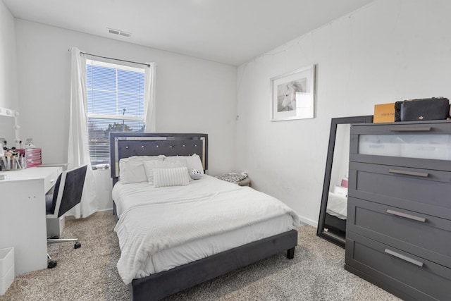 bedroom with light carpet, visible vents, and baseboards