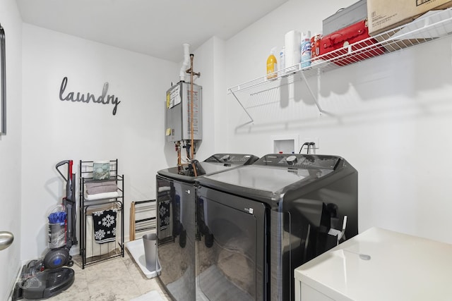 washroom with water heater, laundry area, and separate washer and dryer