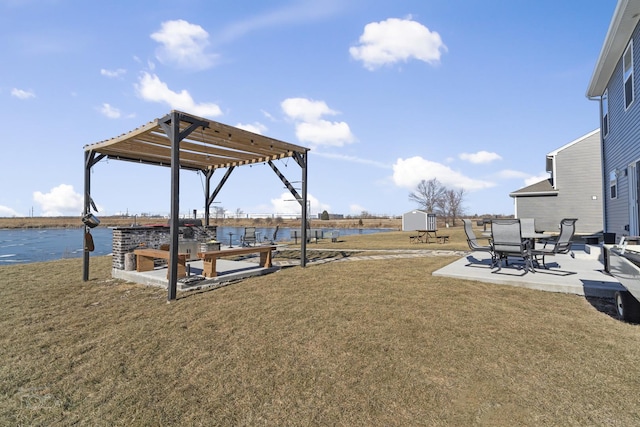 view of yard with an outbuilding, a patio, a storage unit, and a water view