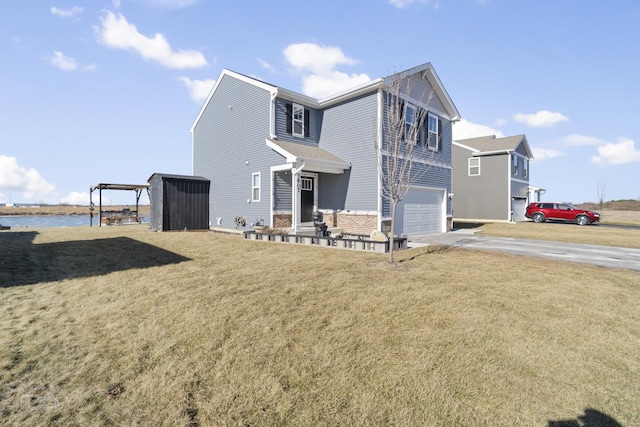 exterior space with an attached garage, a water view, driveway, and a yard