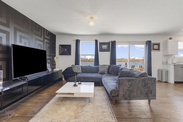 living room featuring wood-type flooring, a water view, and radiator heating unit