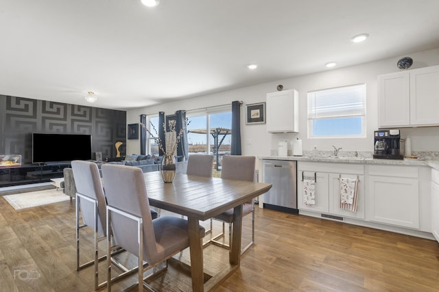 dining area with light wood-type flooring, visible vents, and recessed lighting