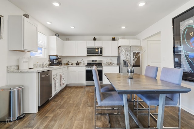 kitchen featuring dark wood-style floors, appliances with stainless steel finishes, white cabinetry, and recessed lighting