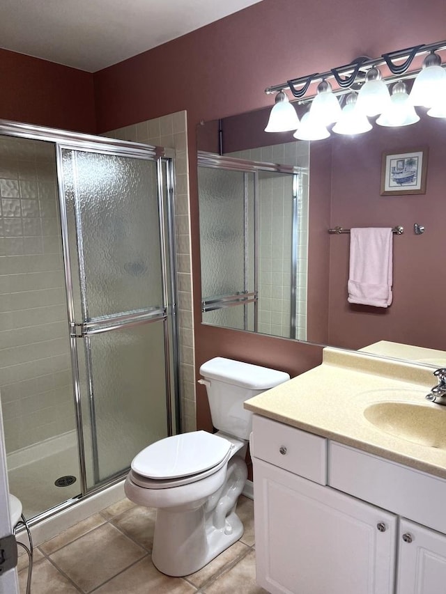 bathroom featuring tile patterned floors, toilet, a shower with door, and vanity