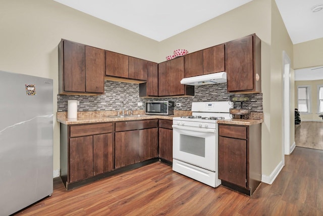 kitchen with sink, backsplash, dark brown cabinets, stainless steel appliances, and dark hardwood / wood-style flooring