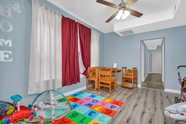 playroom with ceiling fan and light hardwood / wood-style flooring