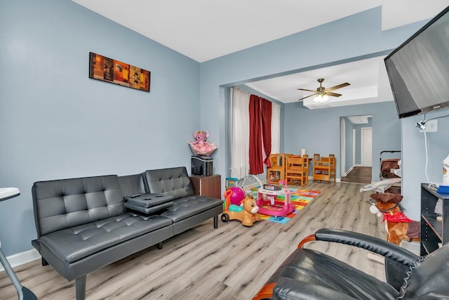 living room with ceiling fan and light wood-type flooring