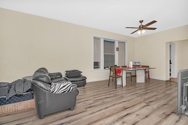 living room with ceiling fan and light hardwood / wood-style flooring